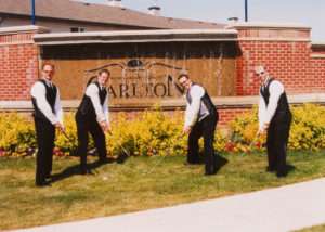 Groomsmen wearing tuxes with gold clubs getting ready